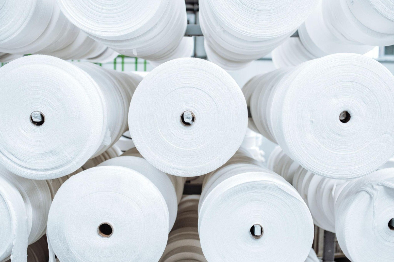 White fabric rolls in a textile warehouse