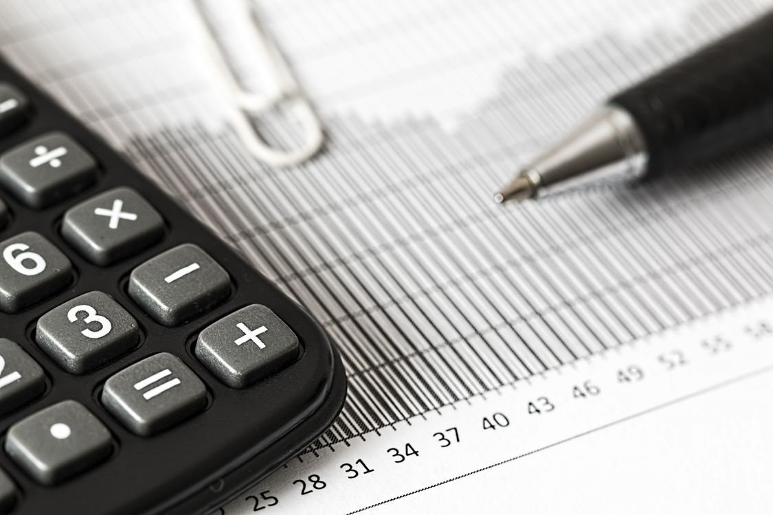Calculator and pen resting beside a printed cost breakdown sheet